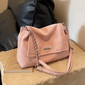 Pink velvet tote bag with silver metal plate and chain strap on stone display - Pink