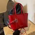 Glossy red leather tote bag with gold branding, featuring top handles and long strap - Red