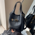 Chic black lychee grain leather bucket bag with gold hardware and a shoulder strap - Black