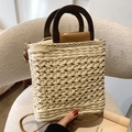 Gewebte Strohtasche mit dunklem Holzgriff und braunem Lederbesatz in Creme-Beige - Beige