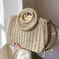 Beigefarbene handgewebte Strohtasche mit Rundgriffen und Kordelzugfutter für den Strand - Beige