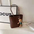 Brown leather tote bag with grainy texture and a cute green rabbit plush pendant accessory - Brown