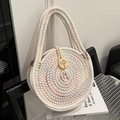 Beige runde Strohtasche mit bunten Wellennähten und einem dekorativen Holzknopf aus Baum - Bunt