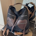 Zaino versatile in tela nera con tasche marroni a forma di cuore e dettagli nappe - Nero