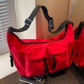 Red utilitarian nylon crossbody tote bag with multi-pocket design and black adjustable straps - Red