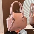Roze retro handtas met zilveren sluiting en schouderband in spiegelbeeld getoond - Roze