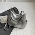 Silver metallic hobo bag with pleated texture and adjustable strap in a fashion setting - Silver
