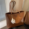Braune Shopper-Tasche aus Leder mit langen Trageriemen und flauschigem Anhänger - Braun mit Anhänger