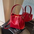 Borsa a secchiello rossa lucida con finiture dorate e tracolla regolabile versatile - Rosso