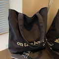 Black canvas tote bag with On the book embroidery and minimalist shoulder strap design - Black