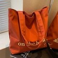Burnt orange canvas tote bag with book embroidery and wide shoulder strap - Orange