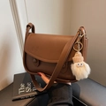 Borsa a sella marrone scuro in ecopelle con ciondolo a mostriciattolo in peluche e tracolla - Caffè Con Ciondoli