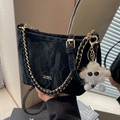 Chic black textured bucket bag with gold chain strap and cloud plush charm - Black
