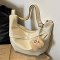 Borsa a mezzaluna color crema con ciondolo in peluche e tracolla regolabile - Bianco Sporco