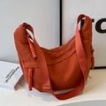 Orange nylon half-moon crossbody bag featuring braided zipper details and wide strap - Orange