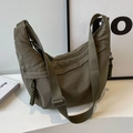 Olive green nylon crossbody dumpling bag with wide adjustable strap and woven zipper pull - Green