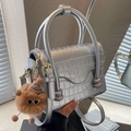 Silver crocodile textured square bag with wavy flap design and plush bear pendant - Silver