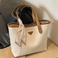 Cream tote bag with brown handles and a decorative silk scarf on a premium leather sofa - Off White