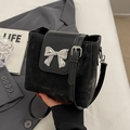 Chic black bucket bag featuring a silver bow accent and adjustable leather shoulder strap - Black