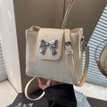 Chic milky white bucket bag with a silver mirror metal bow clasp and adjustable strap - Off-white