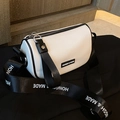White cylinder crossbody bag with black trim and wide logo strap in lychee faux leather - White