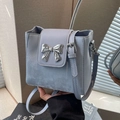 Light blue bucket bag with metallic silver bow detail and adjustable shoulder strap - Blue