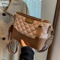 Borsa a secchiello trapuntata kaki e marrone con tracolla geometrica su un trench coat - Cachi