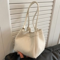 Modern white bucket bag with pleated texture and dual straps in a lifestyle setting - White