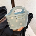 Light blue polka dot crossbody bucket bag with round handles and gold logo detail - Blue