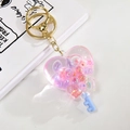 Macro shot of heart-shaped acrylic liquid sand keychain with glitter and gold buckle - Purple