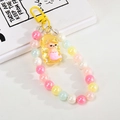 Macro detail of mermaid charm and colorful macaron beads on a creative keychain - Lemon Yellow