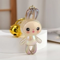 Macro view of iridescent acrylic bunny keychain with gold bell and metallic clip - Gray