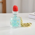 Dettaglio del portachiavi a rossetto con sabbia liquida blu e finiture dorate lucide - Verde Frutta