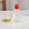 Vue détaillée du porte-clés rouge à lèvres liquide avec texture coquillage et anneau doré - Blanc