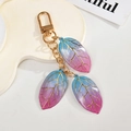 Macro detail of colorful gradient resin leaf charms with gold veins and lobster clasp - Blue-Pink Gradient