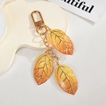 Detail of gradient autumn leaf keychains with gold veins and sparkling glitter finish - Golden Orange Gradient