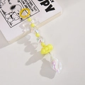 Dettaglio di un ciondolo giallo con fiocco luminoso e conchiglia per borse e chiavi - Anello Colorato e Piccola Catena di Conchiglia / Giallo Limone