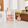 Detail of pink milk tea cup keychain with glowing beads, liquid sand and golden ring - Glowing Milk Tea Cup Style / Pink