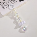 Close-up of white bow and iridescent heart pendant keychain with beaded details - White