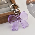 Macro detail of purple transparent acrylic bow pendant with silver spring ring clasp - Purple