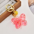 Dettaglio portachiavi a farfalla rosa con glitter dorati e piccolo campanello - Rosso Fluorescente