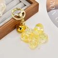 Macro view of butterfly liquid keychain with gold bell and iridescent star sequins - Fluorescent Lemon Yellow