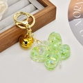Close-up of green butterfly keychain with glitter sequins and gold bell detail - Noctilucent Green