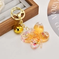 Detail of butterfly oil-filled acrylic keychain with gold sequins and charms - Glitter Orange