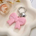 Rosa Acryl-Schleifen-Schlüsselanhänger mit Silberherz-Anhänger auf weißem Tablett - Rosa