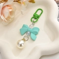 Detail of sweet mint green bow keychain with white pearl pendant and colorful beads - Green