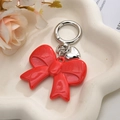 Polished red acrylic bow keychain with silver heart charm and round spring buckle - Red