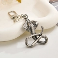 Detailed macro view of vintage cobra metal keychain with intricate scale texture - Cobra