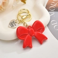 Chic red acrylic bow keychain with gold heart charm for stylish bag accessories - Red