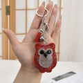 Detail of owl keychain featuring sparkling rhinestones, red tassel, and silver bell - Keychain + Owl / Multicolor Red